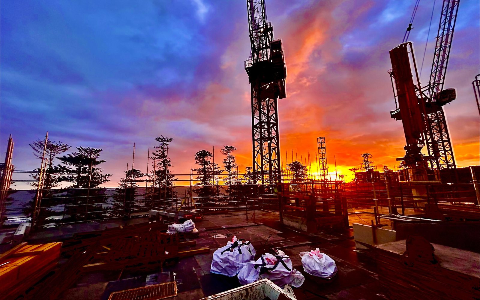 Tower cranes over Royal Far West construction works at sunset